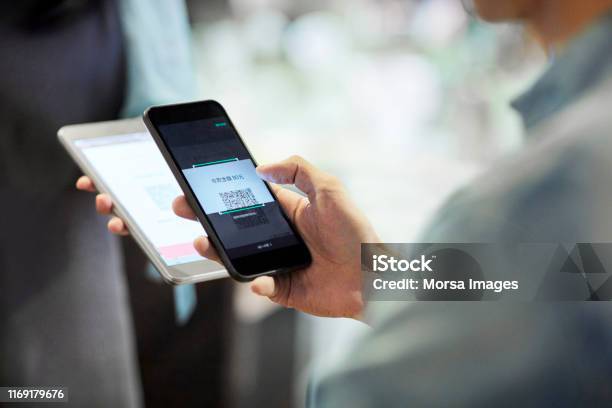 Man Paying Through Smart Phone In Cafe Stock Photo - Download Image Now - Paying, QR Code, Mobile Phone