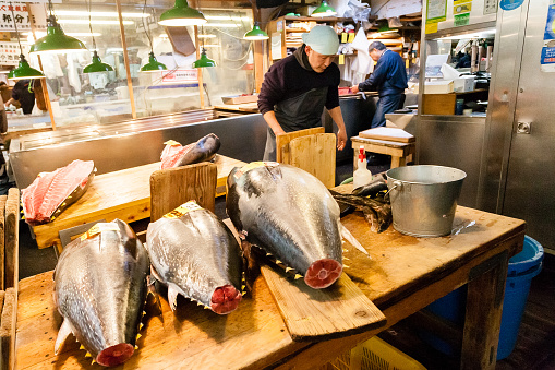 Tokyo, Japan - January 15, 2010: Early morning at Fish Market. Vendor cutting tuna at Tsukiji Fish Market in Tokyo
