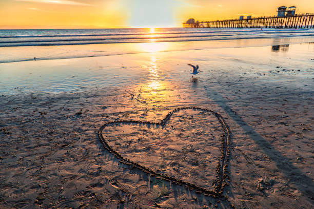 A valentine drawn into the sand at the Oceanside Pier, located in northern San Diego County about 30 miles north of the city of San Diego, shot at sunset.