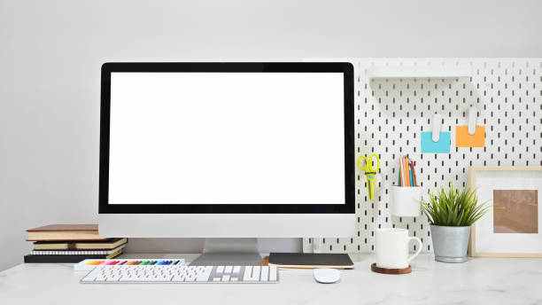 istock Contemporary workspace with empty screen computer and office supplies on marble table. 1169182836