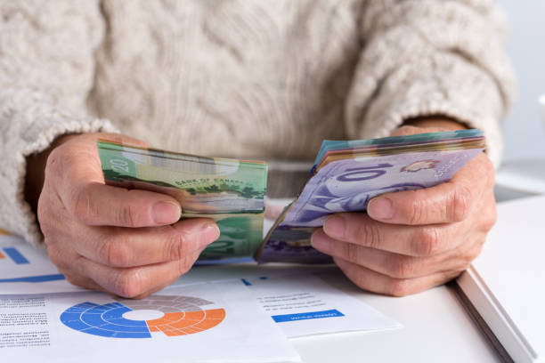 midpart kobiety liczącej pieniądze na stole - waluta kanady zdjęcia i obrazy z banku zdjęć