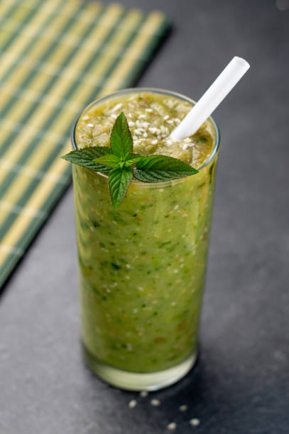 istock Vegetable green smoothie in a glass on a dark background 1169185589