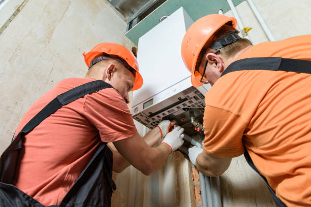 pracownicy podłączają rury do kotła gazowego. - water heater boiler installing repairing zdjęcia i obrazy z banku zdjęć