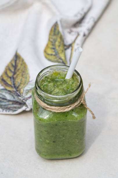 istock Vegetable green smoothie in a glass jar on a light background 1169186556