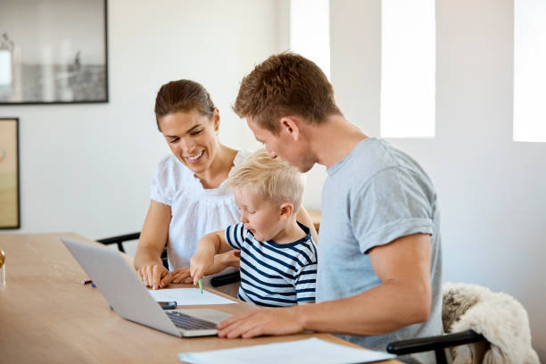 istock Father and mother looking at son drawing at table 1169191853