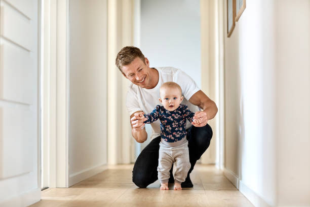 istock Happy man teaching little son to walk in corridor 1169191923