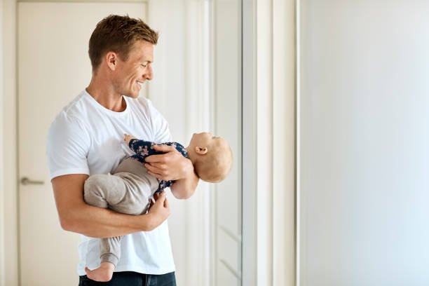 istock Smiling father carrying son in corridor at home 1169191934
