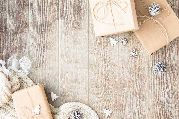 クリスマスの作曲。クリスマスプレゼント、ニット毛布、松ぼっくり、木製の白い背景にモミの枝。フラットレイ、トップビュー、コピースペース - 冬 写真 ストックフォトと画像