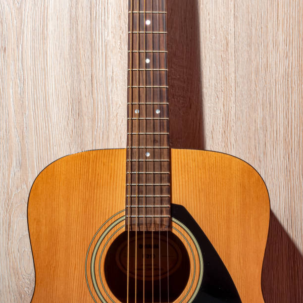 istock Classical acoustic guitar brown on light wooden background 1169194829