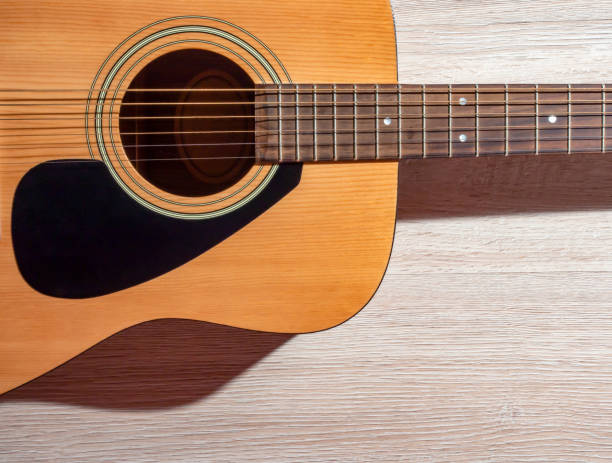 istock Classical acoustic guitar brown on light wooden background 1169194846