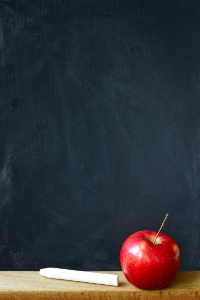 istock Close-up black chalk board in chalk stains chalk board and red apple, selective focus, copyspace 1169195987