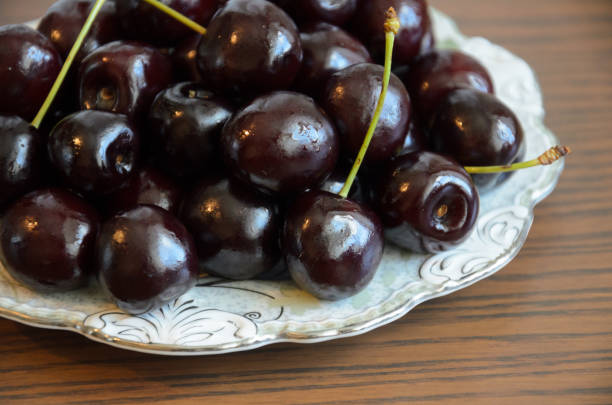 istock Wet chilled cherries with peduncles on saucer on table 1169198461