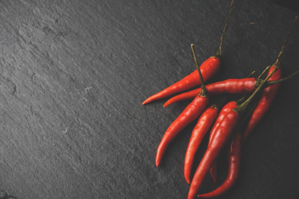 istock Chilies on slate, stone grunge texture. 1169198869