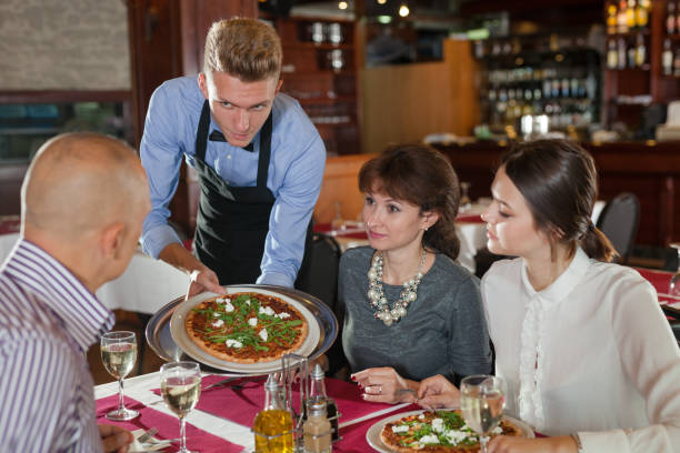 istock Waiter serving pizza to visitors 1169200002