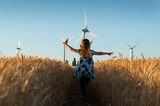 女の子は、風力エネルギーへの道を実行しています。 - the way forward ストックフォトと画像