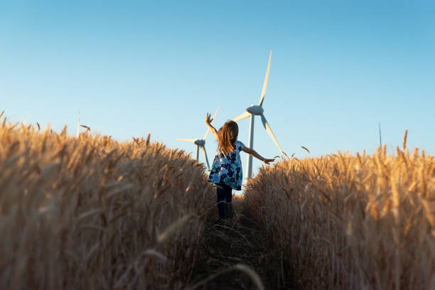 mädchen läuft den weg zur windenergie - fuel and power generation power wind power supply stock-fotos und bilder