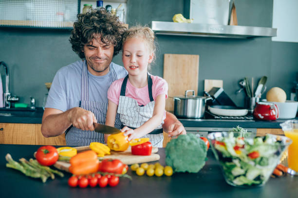 istock Father and daughter making salad 1169206296