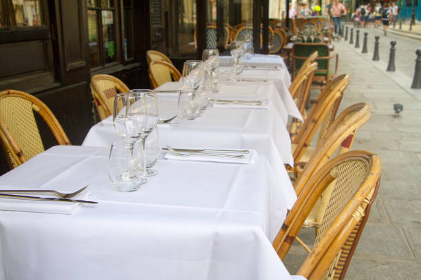 istock Close-up of several served tables with white tablecloths and ward chairs, selective focus 1169208255