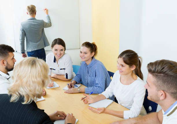 istock Group of smiling students brainstorming in classroom 1169209971