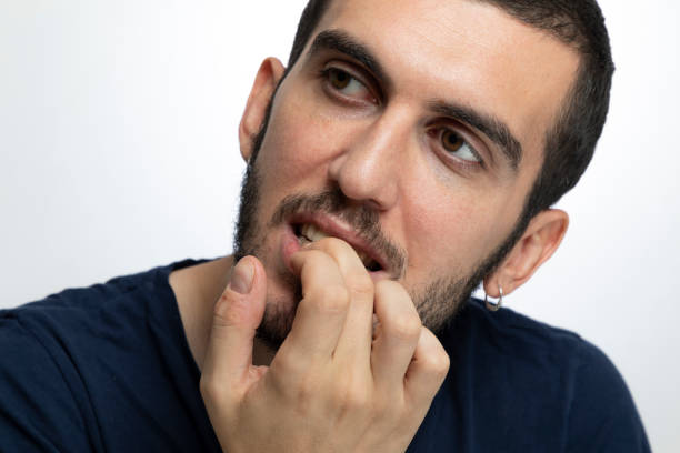 istock Nervous male biting fingernails  over isolated background 1169212335