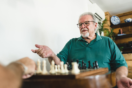 Elderly man in doubt playing chess