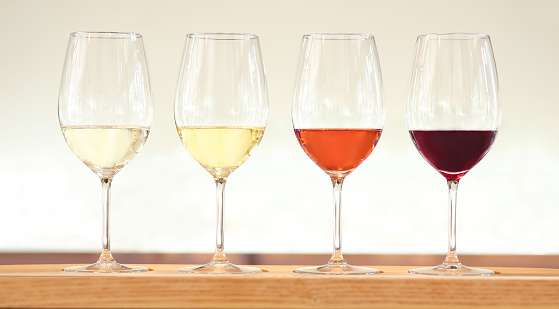 Four wine tasting glasses with white, red and rose wine