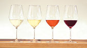 Four wine tasting glasses with various wines