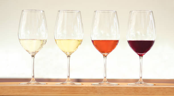 Four wine tasting glasses with various wines - fotografia de stock