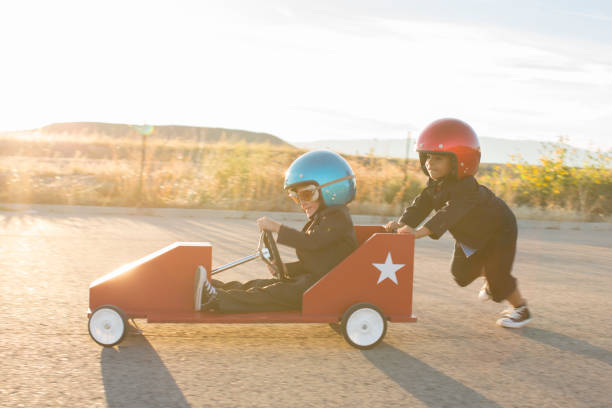 young business boys racing a toy car - car child teamwork sports race fotografías e imágenes de stock