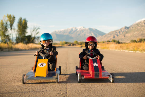 młodzi chłopcy biznesu wyścigi samochodki - car child teamwork sports race zdjęcia i obrazy z banku zdjęć