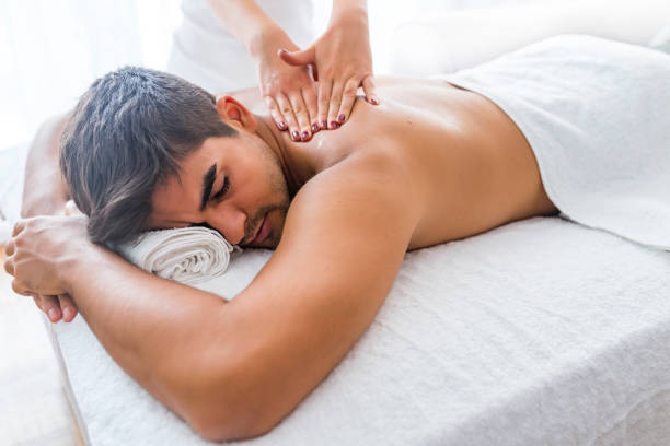 istock Young man is enjoying massage on spa treatment 1169228507