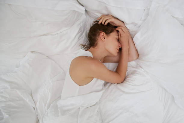 istock Young beautiful woman sleeping in bed, white sheets, top view 1169228812