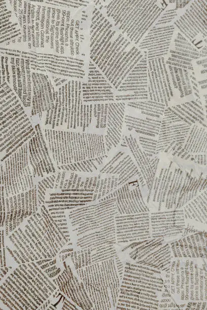 Photo of Black and white repeating torn newspaper background. Continuous pattern left, right, up and down