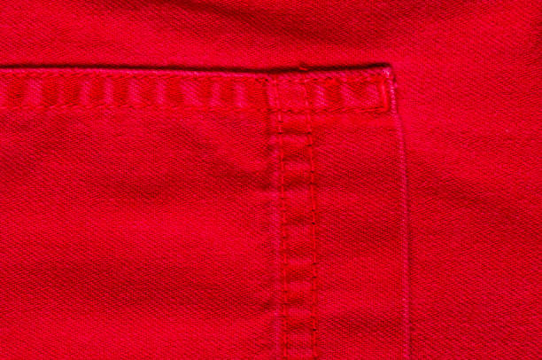 istock clothing items stonewashed red cotton fabric texture with seams, clasps, buttons and rivets, macro 1169232758