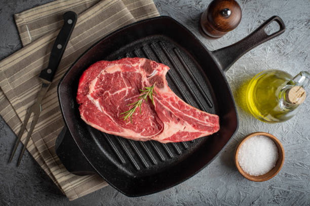 istock raw ribeye steak on cast iron pan 1169233829