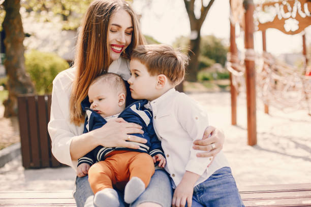 istock Mother with two children playing in a summer park 1169238228