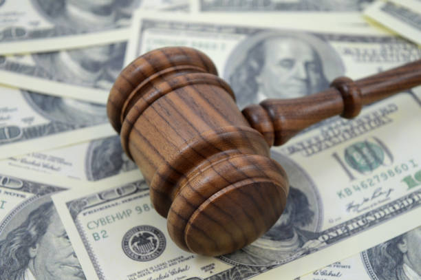 Law and Money An image focused on the legal side of monetary gains using a gavel and an abundance of American cash as a background. lawsuit photos stock pictures, royalty-free photos & images