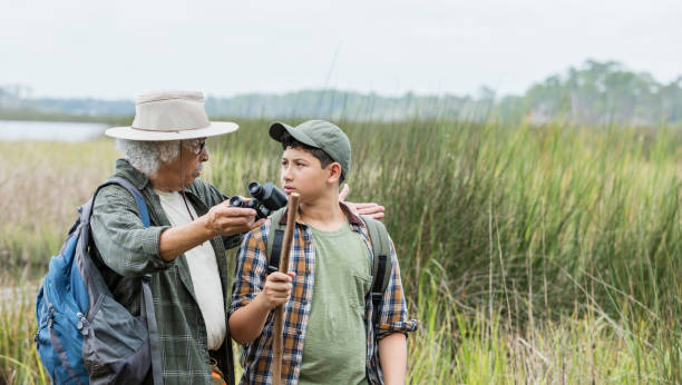 istock Hispanic boy hiking with grandfather, bird watching 1169243078