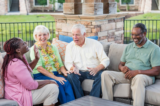 istock Two older couples hanging out on patio, conversing 1169243120