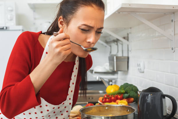 istock Young woman cooking romantic dinner at home taste soup 1169246821