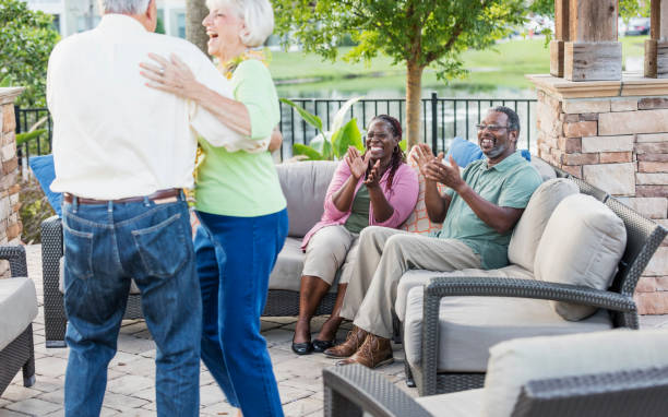 istock Senior couple dancing on patio, friends clapping 1169248959