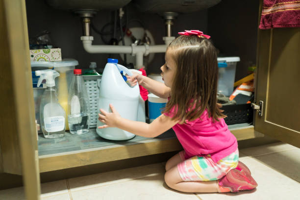 Female Toddler In Kitchen At Home Little kid removing container from cabinet in kitchen at home poisonous stock pictures, royalty-free photos & images