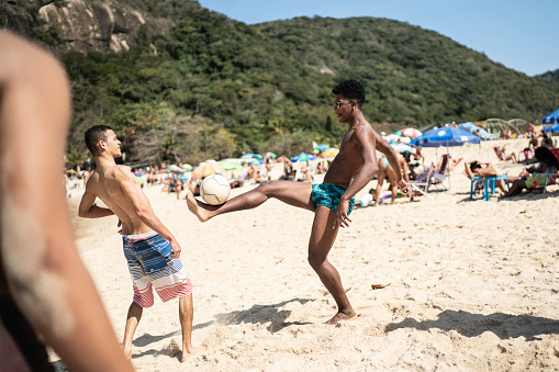 Young men doing kick ups in the beach