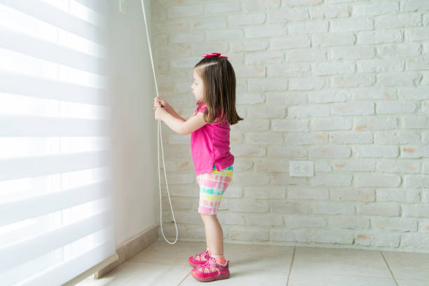 fenêtre d'ouverture de petit enfant en bas âge dans la salle de séjour - clothing store photos et images de collection