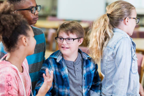 istock Boy with down syndrome, classmates in school library 1169254764