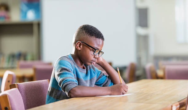 istock African-American boy in elementary school, writing 1169254960