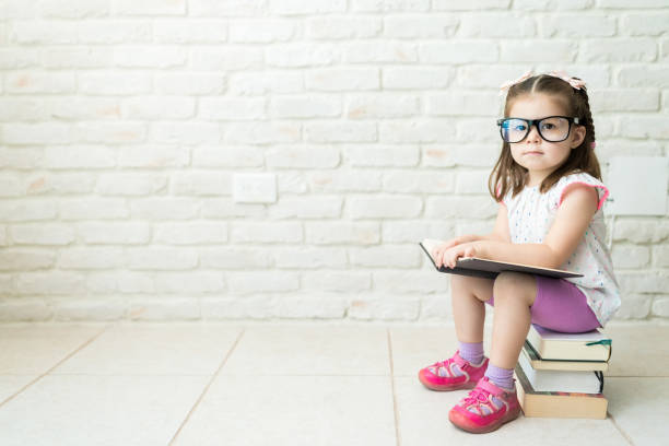istock Geeky Little Kid Increasing Her Knowledge With Books 1169260533
