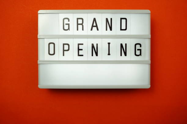 istock Top view Grand opening word in light box flat lay with space copy on red background 1169266785