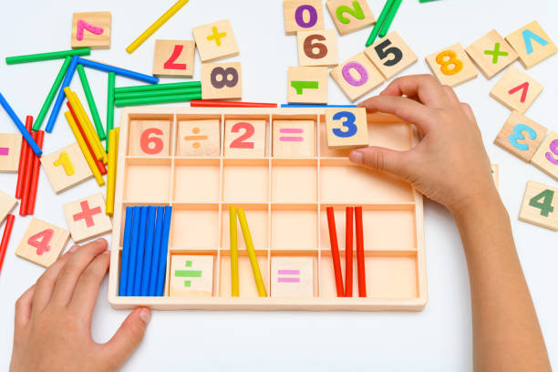 kid doing division equation using counting rods stock photo