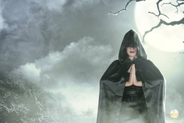 istock Witch woman in black hooded doing ritual magic 1169268716